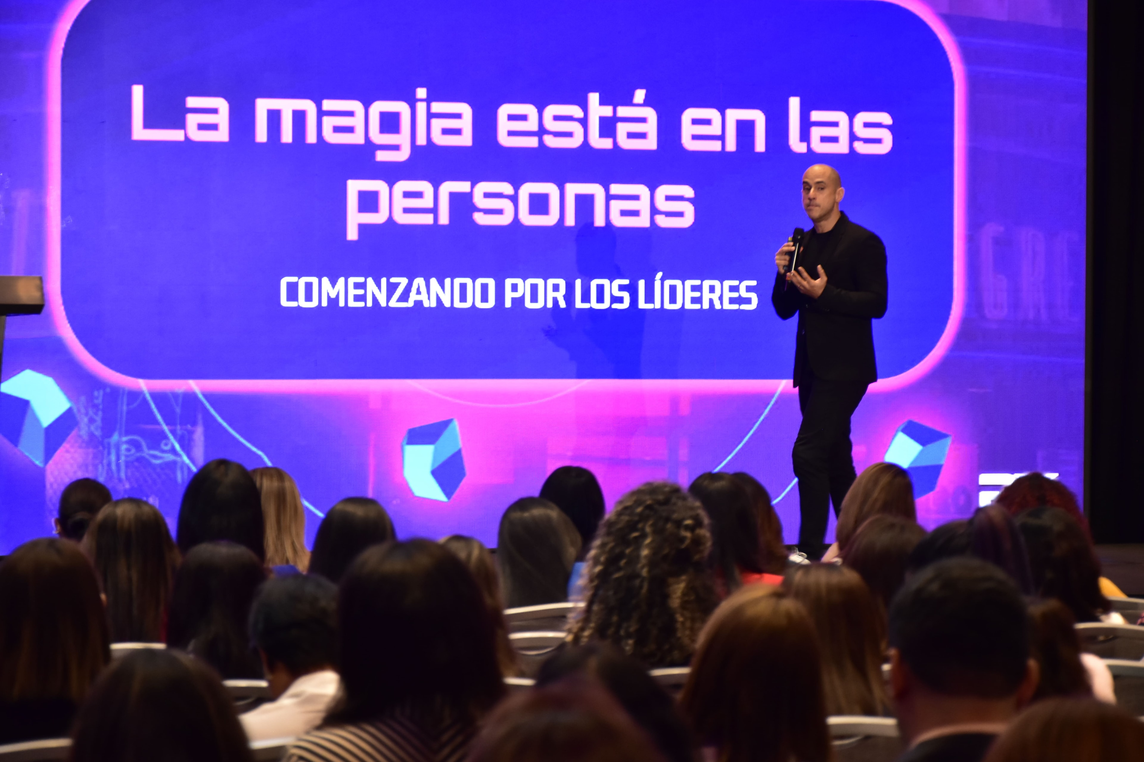 Speaker en el escenario — La magia está en las personas