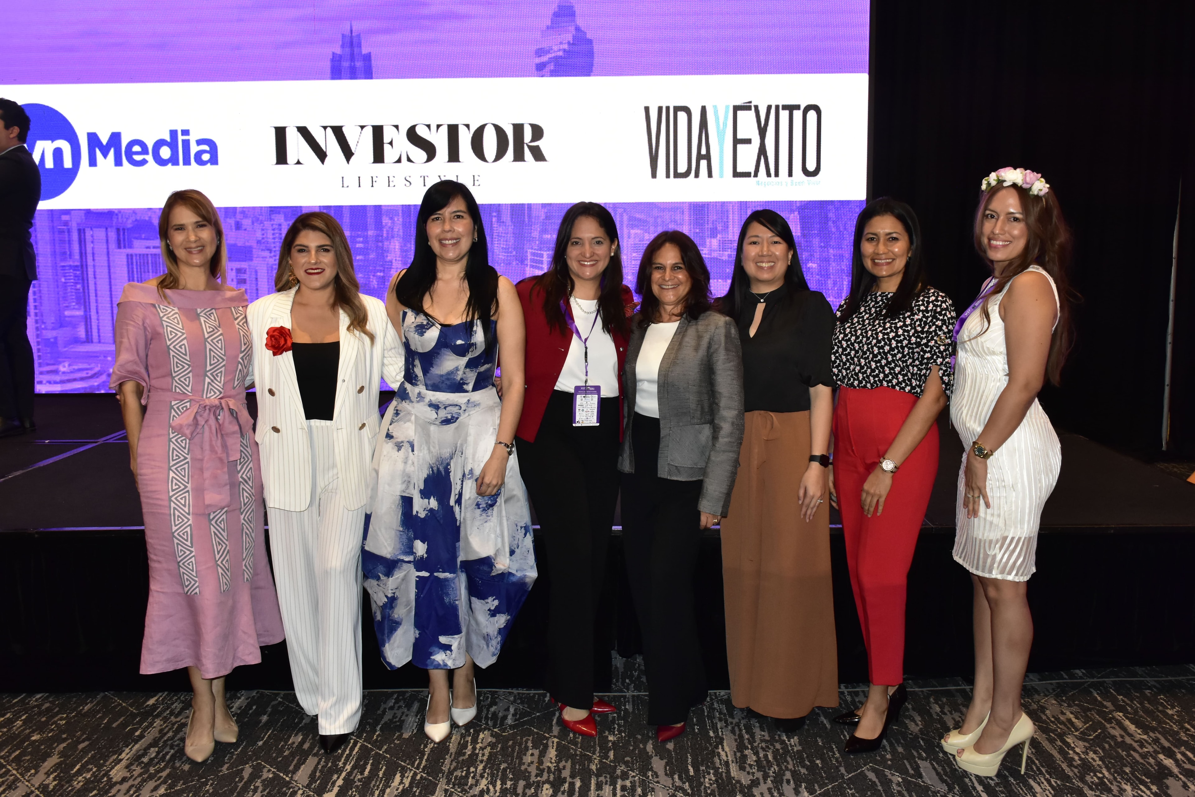 Grupo de ocho mujeres líderes frente al escenario WEF con logos TVN Media, Investor Lifestyle, Vida y Éxito